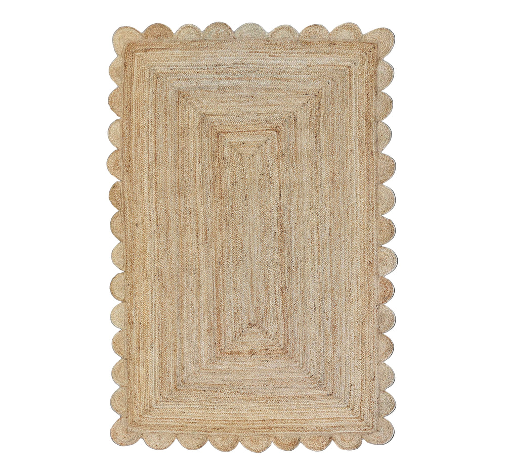 Beige braided rug with scalloped edge on a white background