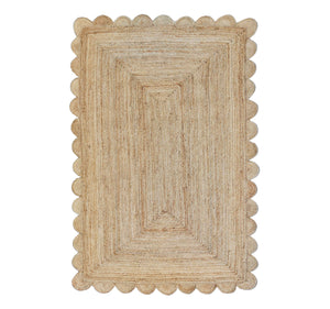 Beige braided rug with scalloped edge on a white background