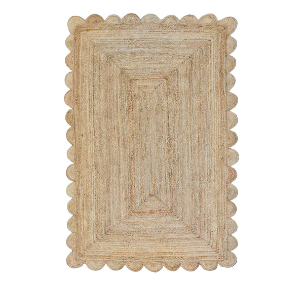 Beige braided rug with scalloped edge on a white background