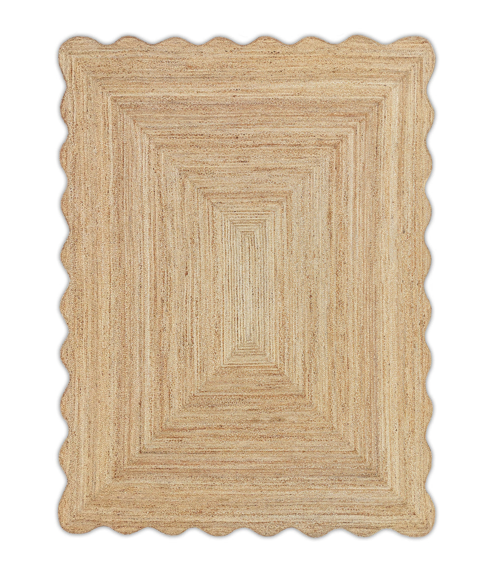 A beige-colored, textured jute area rug with a wave scalloped edge.