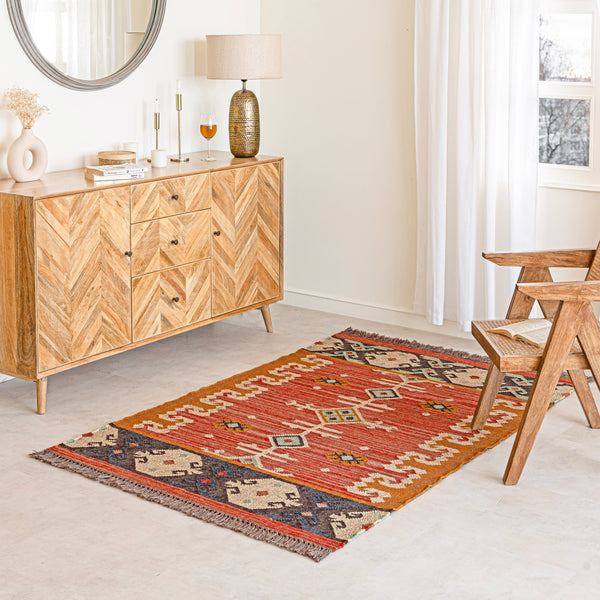 Jute Kilim Rug in living room with wooden sideboard, and wooden chair.