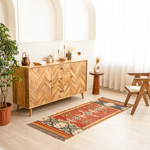 Kilim Rug with wooden sideboard and decorative items in a bright room.