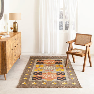 Living room with a patterned rug, wooden sideboard, and chair.