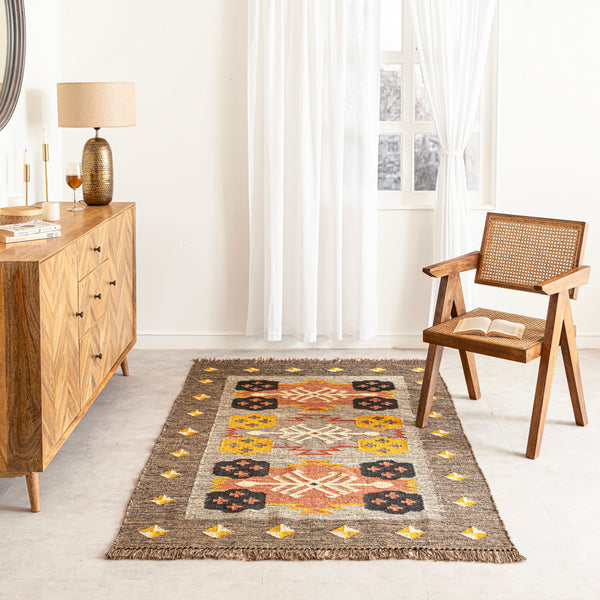 Living room with a patterned rug, wooden sideboard, and chair.