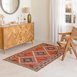 Wool Jute Kilim Rug in Living room with wooden sideboard, and wicker chair.